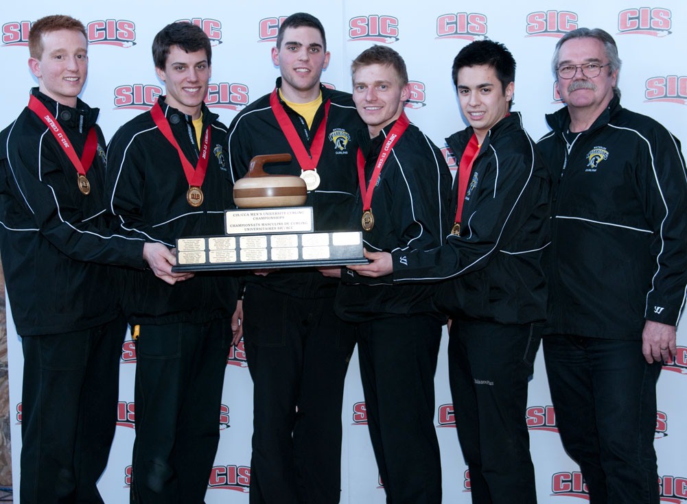 The men's curling team poses with their trophy and coach.