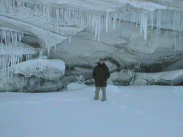 [Before a blue cliff of ice]