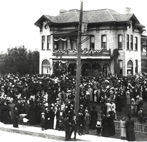 [Crowd around the yellow brick house]