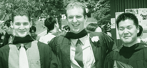 [Three happy grads in gowns]