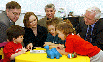 [Three kids and a blue dinosaur]