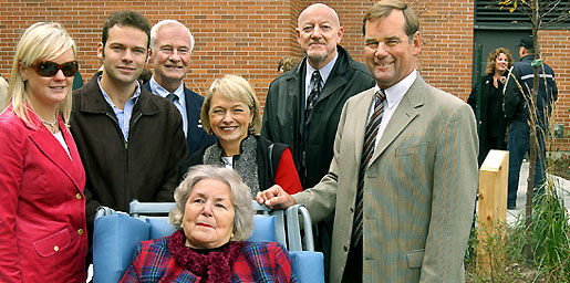 [Smiling group at left, tree at right]