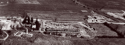 [Aerial view of construction and empty land]