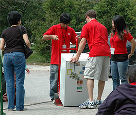 [Students in red T-shirts hoisting the goods]