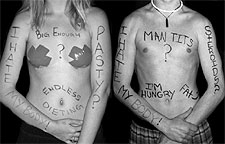 [Male and female bodies, with painted slogans]
