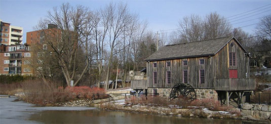 [Modern apartment blocks and 19th-century mill]