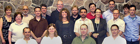 [Group posing in front of stone wall]