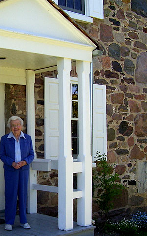 [Woman at doorway of stone house]