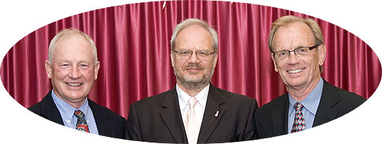 [Three men in front of a curtain]