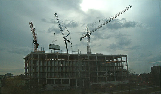 [Unfinished building against dramatic clouds]