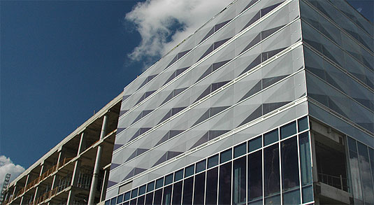 [Against a blue sky, shows facade on half of building]