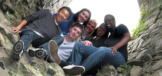 [Six posing in a rock formation]
