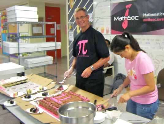 Ian Goulden cuts cake for students.