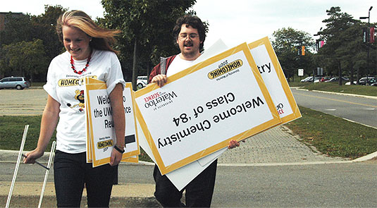 [Volunteers carrying reunion signs]