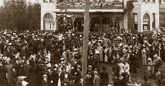 [Mob on lawn and street, all wearing hats]