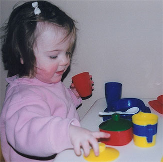 [Child with brightly coloured toys]