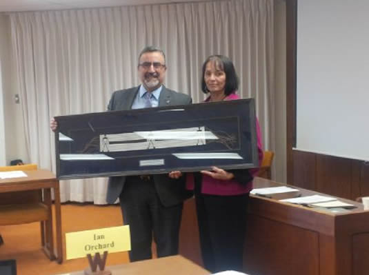 Feridun Hamdullahpur and Rebecca Jameson hold a framed Wampum Belt.