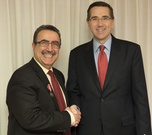 Feridun Hamdullahpur shakes John Milloy's hand after receving the Diamond Jubilee medal.