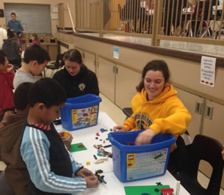 Kids and volunteers play with Lego bricks.