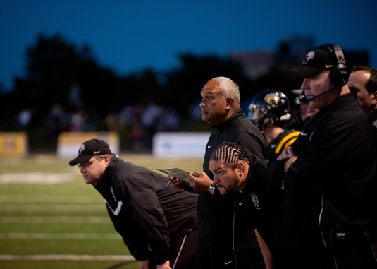 Coach Joe Paopao on the sidelines at a Warriors football game.