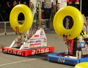 A pair of robots weilding inflatable rings at a FIRST event.