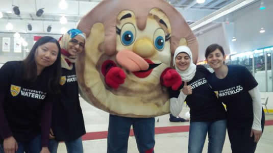 University of Waterloo students pose with a pancake mascot at the Elmira Maple Syrup Festival.