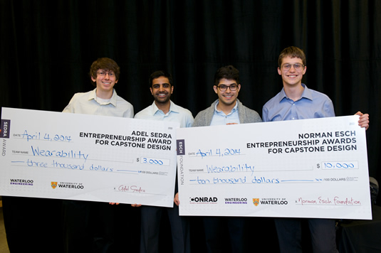 Wearability team members hold their oversized cheques.