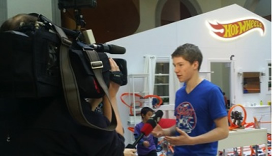 Andrew Smiles speaks to the media in front of the Hot Wheels playset.