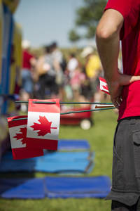Close-up of a child holding a miniature Canadian flag.