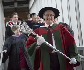Mark Walker holding the university's mace in a Convocation procession.