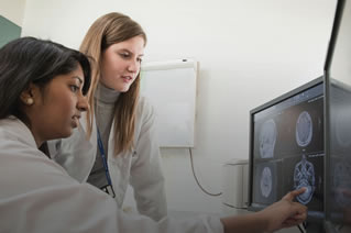 Two female researchers look at a brain scan.