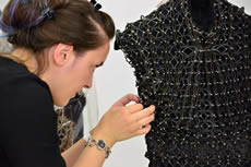 A worker helps put together an article of clothing.