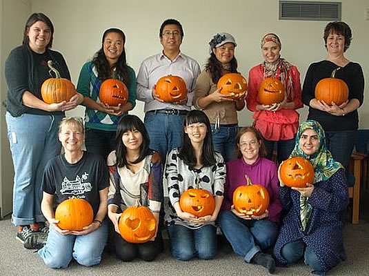 Members of the International Spouses group pose with their Jack O'Lanterns.