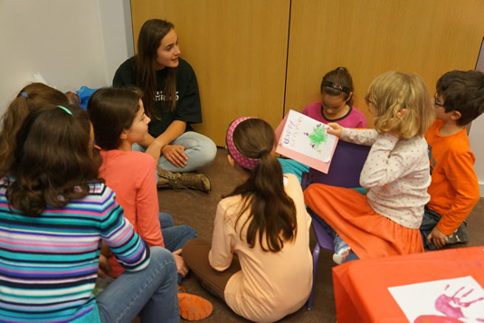 A Waterloo volunteer sits with a number of children.