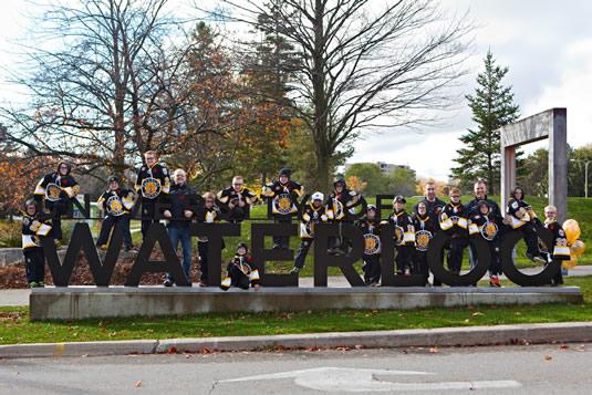 The Waterloo Wolves junior hockey team poses at the University of Waterloo South Campus entrance sign.