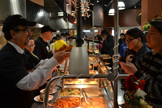 Feridun Hamdullahpur and other senior leaders serve food at the Village 1 cafeteria.