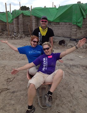 Habitat for Humanity volunteers horse around in a wheelbarrow.